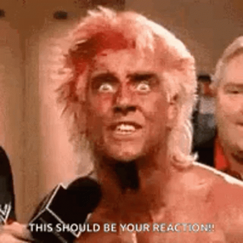 A Shirtless Man With Red Hair Is Talking Into A Microphone . GIF