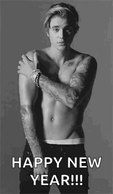 A Shirtless Man With Tattoos On His Arms Is Standing In A Black And White Photo And Wishing A Happy New Year . GIF