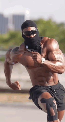 A Shirtless Muscular Man Wearing Sunglasses And A Black Mask Is Running GIF