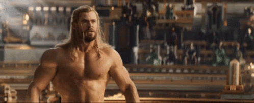a shirtless thor is standing in front of a crowd of people