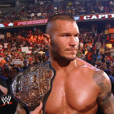A Shirtless Wrestler Holds A Wrestling Belt In Front Of A Crowd GIF