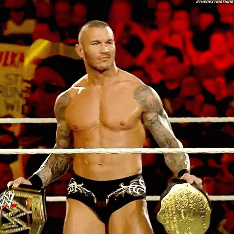 A Shirtless Wrestler In A Wrestling Ring Holding A Wwe Championship Belt GIF