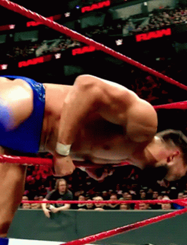 A Shirtless Wrestler In A Wrestling Ring With A Crowd Watching And A Sign That Says Rams GIF