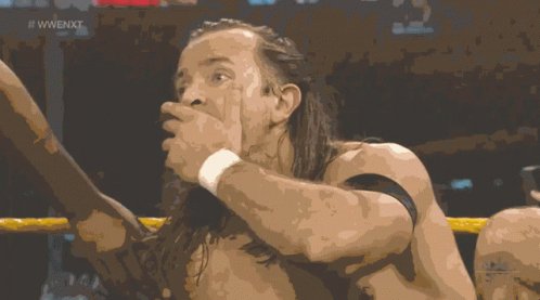 A Shirtless Wrestler In A Wrestling Ring With The Words Next Live Below Him GIF