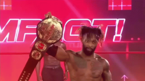 A Shirtless Wrestler Is Holding A World Heavyweight Championship Belt In Front Of A Pink And Purple Background . GIF