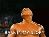 A Shirtless Wrestler Is Standing In A Ring With His Eyes Closed And The Words `` Bask In My Glory '' . GIF