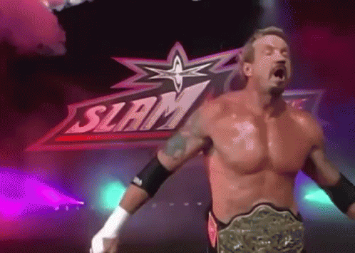 A Shirtless Wrestler Is Standing In Front Of A Sign That Says Slam GIF