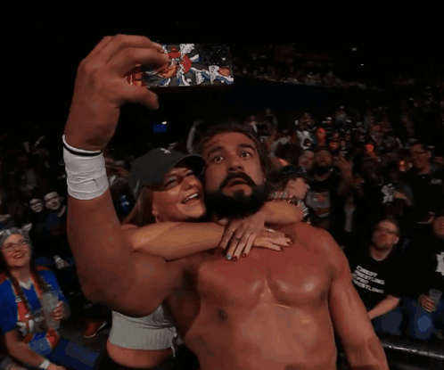 A Shirtless Wrestler Takes A Selfie With A Fan In The Crowd GIF