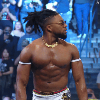 A Shirtless Wrestler Wearing A Necklace That Says Trick Willy GIF