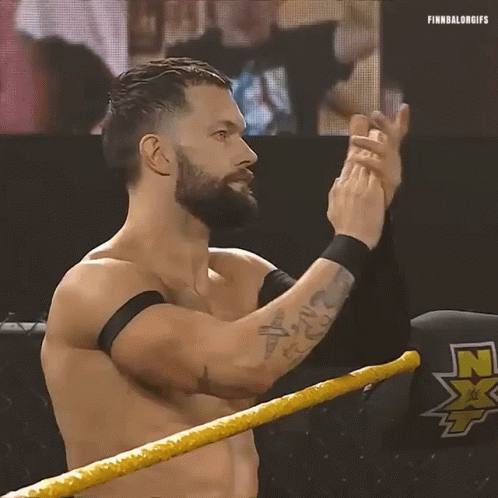 A Shirtless Wrestler With A Beard Is Standing In A Wrestling Ring Clapping His Hands . GIF