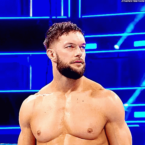 A Shirtless Wrestler With A Beard Is Standing In A Wrestling Ring . GIF