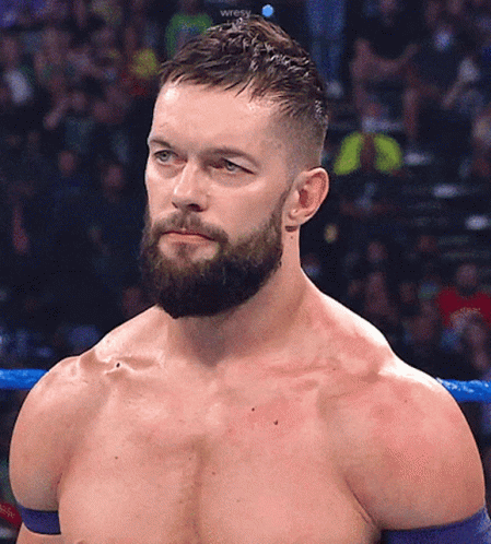 A Shirtless Wrestler With A Beard Stands In A Ring GIF