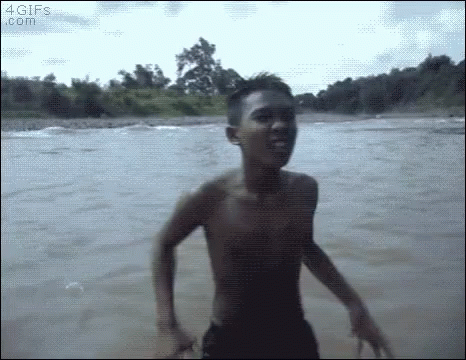A Shirtless Young Man Is Jumping Into A River Without A Shirt On . GIF