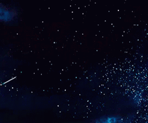 A Shooting Star Flies Through A Dark Night Sky GIF
