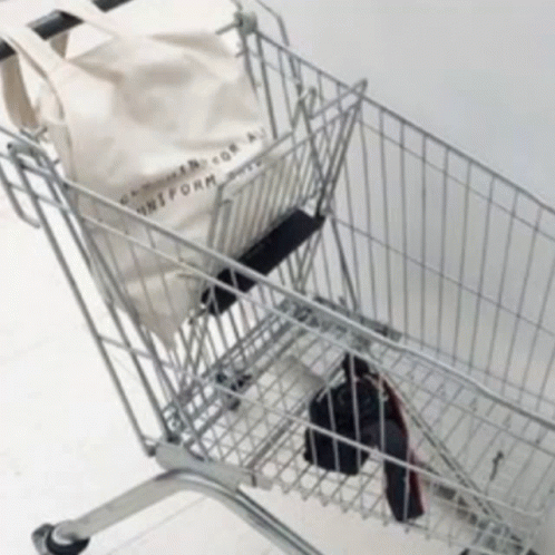 A Shopping Cart With A Tote Bag That Says Uniform On It GIF