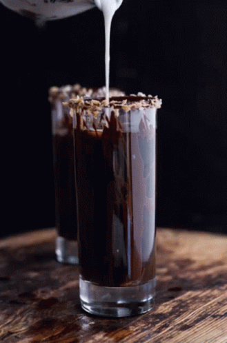 A Shot Glass Filled With Chocolate And Whipped Cream Being Poured Into It GIF