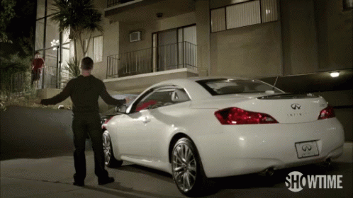 A Showtime Ad Shows A Man Standing Next To A White Infiniti GIF
