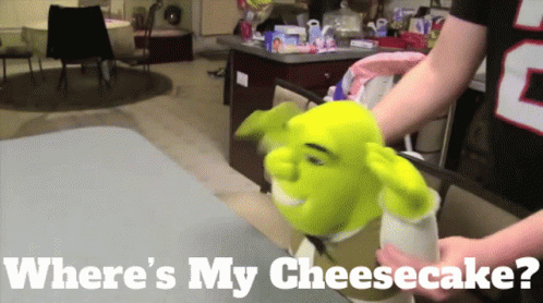 A Shrek Puppet Is Being Held By A Person With The Words Where 'S My Cheesecake GIF