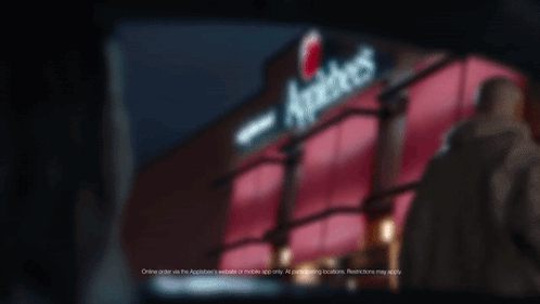 A Sign For Applebee 'S Is Lit Up In The Dark GIF