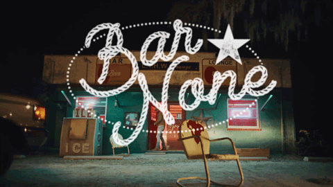 A Sign For Bar None With A Yellow Chair In Front Of It GIF