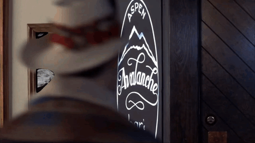 A Sign For The Aspen Avalanche Bar Is Lit Up In The Dark GIF