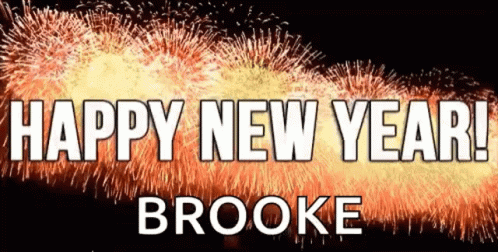 A Sign That Says Happy New Year Brooke In Front Of Fireworks GIF