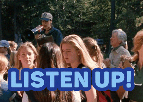 A Sign That Says Listen Up In Front Of A Crowd GIF