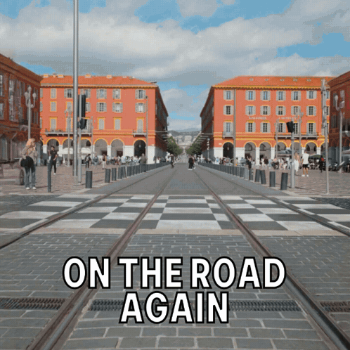 A Sign That Says On The Road Again In Front Of A Busy Street GIF