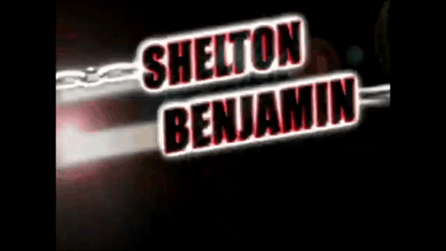 A Sign That Says Shelton Benjamin With A Chain Behind It GIF