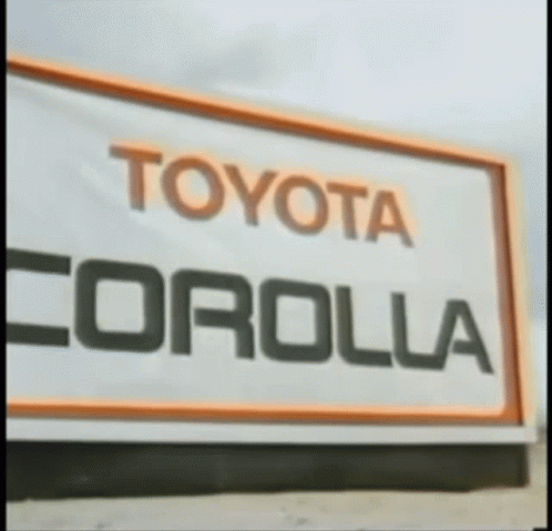 A Sign That Says Toyota Corolla In Black And Orange GIF