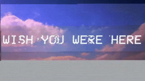 A Sign That Says Wish You Were Here In Front Of A Cloudy Sky GIF