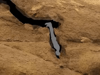 A Silhouette Of A Bat Is Flying Over A Rocky Area GIF