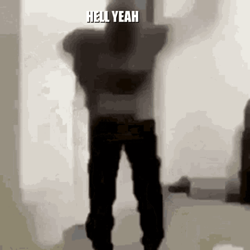 A Silhouette Of A Man Dancing In A Room With The Words `` Hell Yeah '' Written On The Bottom Of The Image . GIF