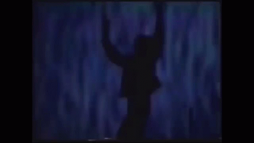 a silhouette of a man in a suit with his arms outstretched .