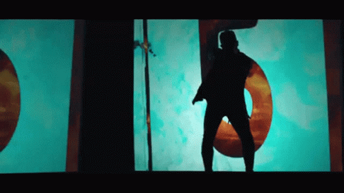 A Silhouette Of A Man Is Dancing In Front Of A Large Number 5 GIF