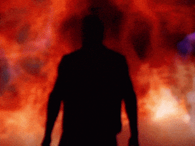 A Silhouette Of A Man Is Standing In Front Of A Red Background GIF