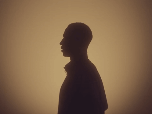 a silhouette of a man 's head is against a tan background