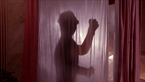 A Silhouette Of A Man Standing Behind A Pink Curtain GIF