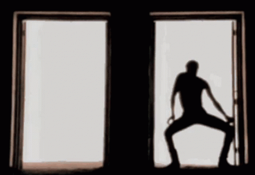 a silhouette of a man standing in an open door