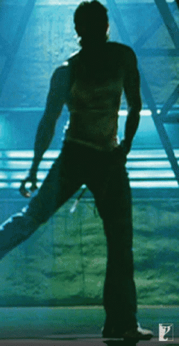 A Silhouette Of A Man Standing In Front Of A Blue Wall GIF