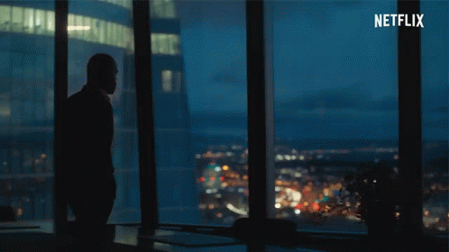 A Silhouette Of A Man Standing In Front Of A Window With Netflix Written In The Corner GIF