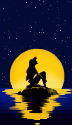 A Silhouette Of A Mermaid Sitting On A Rock Looking At The Moon GIF