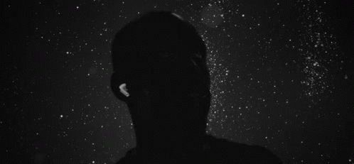 A Silhouette Of A Person Falling Into The Water Surrounded By White Particles On A Black Background . GIF