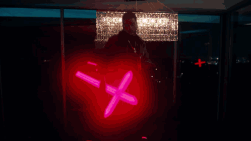 A Silhouette Of A Person In A Dark Room With A Blue Light Behind Him GIF