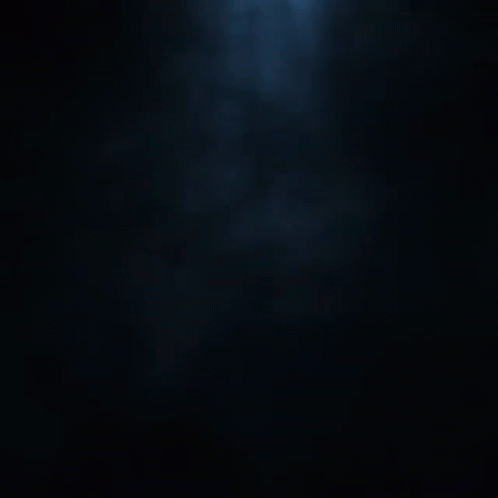 A Silhouette Of A Person In A Dark Room With A Hood GIF