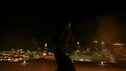 A Silhouette Of A Person Standing In A Dark Room With A Light On The Ground GIF