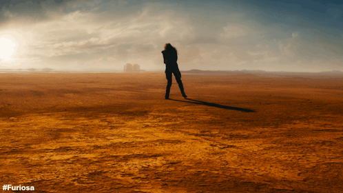 A Silhouette Of A Person Standing In A Desert With #Furiosa Written On The Bottom GIF