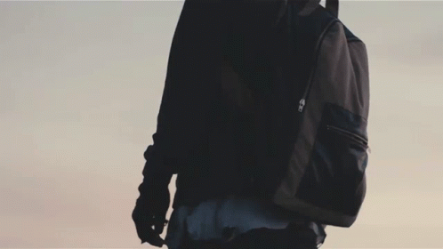 A Silhouette Of A Person Standing On Top Of A Wall With A Blue Sky In The Background GIF
