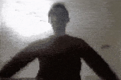 A Silhouette Of A Person With Their Arms Outstretched Against A Wall GIF
