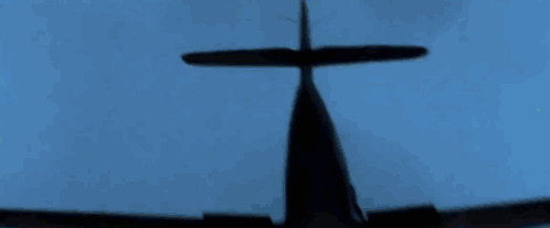 A Silhouette Of A Plane Flying In The Blue Sky GIF